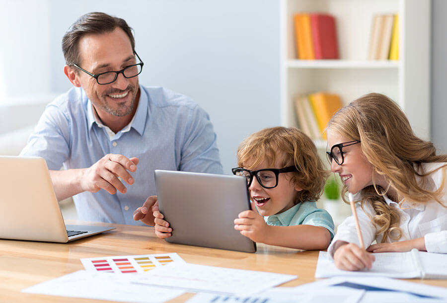 father and kids wearing glasses while working on homework