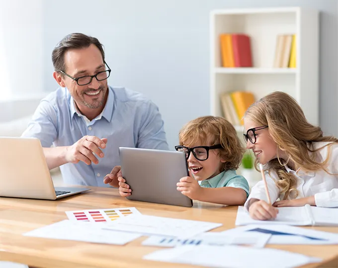 father and kids wearing glasses while working on homework